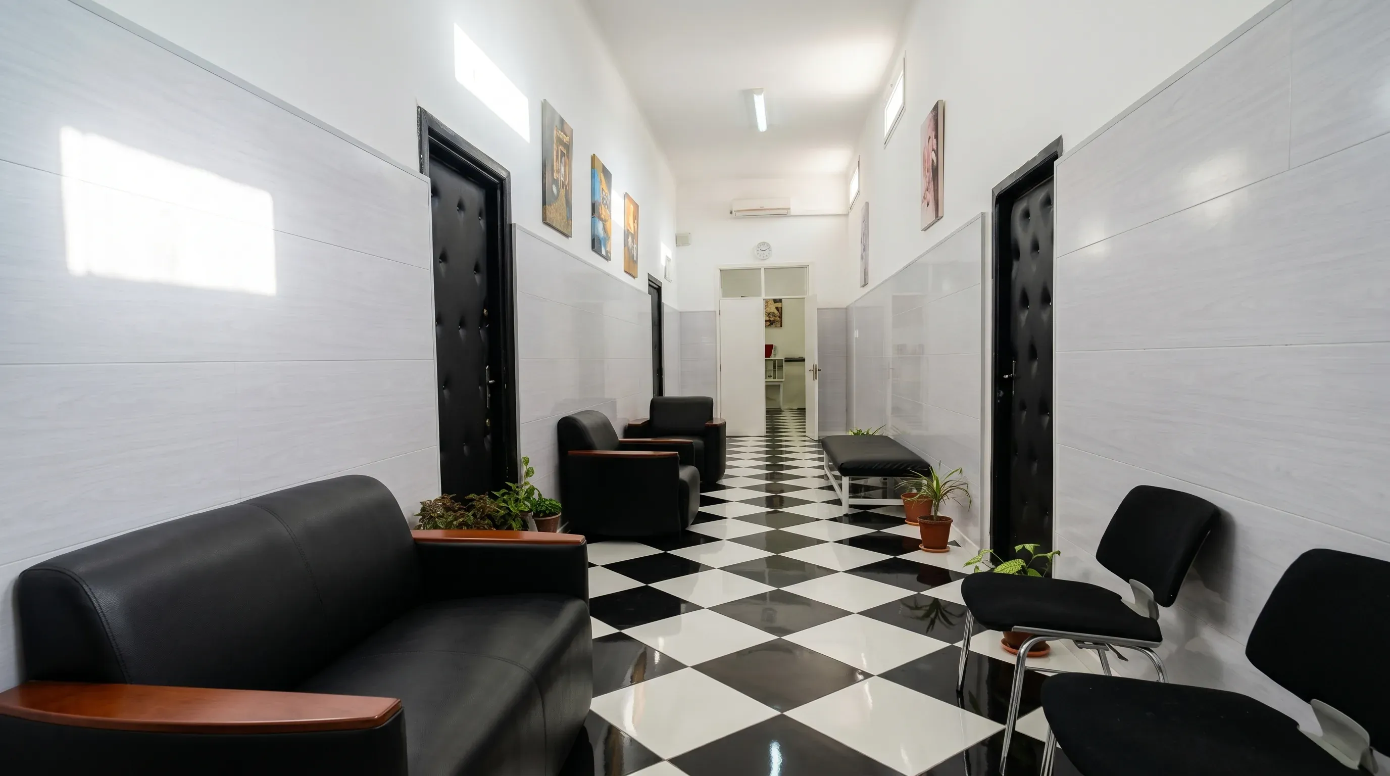 Espace d'attente du service : banquettes, sièges et sol en damier noir et blanc