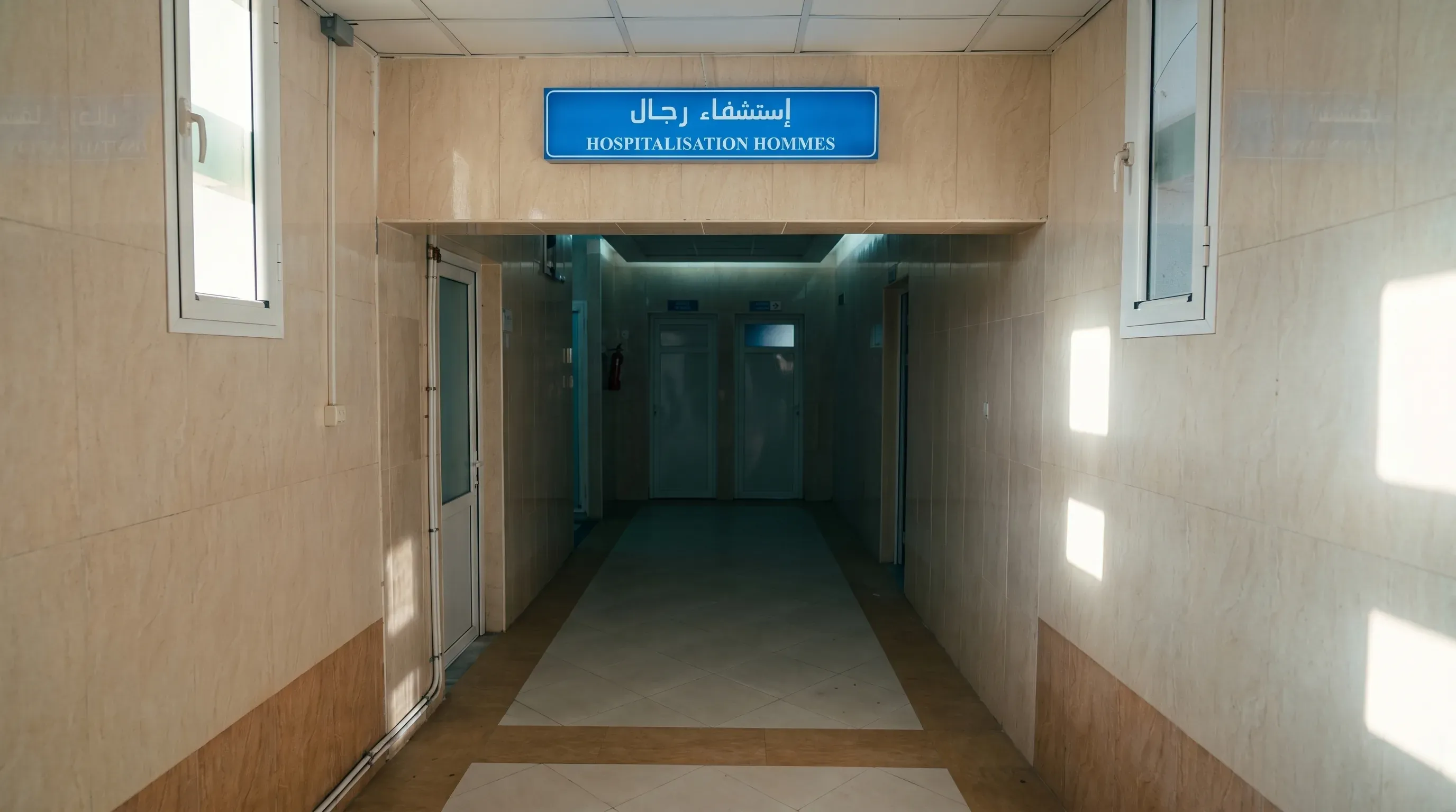 Accès à l'unité d'hospitalisation hommes, signalé par son enseigne bilingue